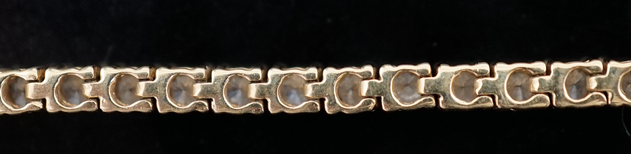 A modern 18ct gold and fifty nine stone round brilliant cut diamond set line bracelet